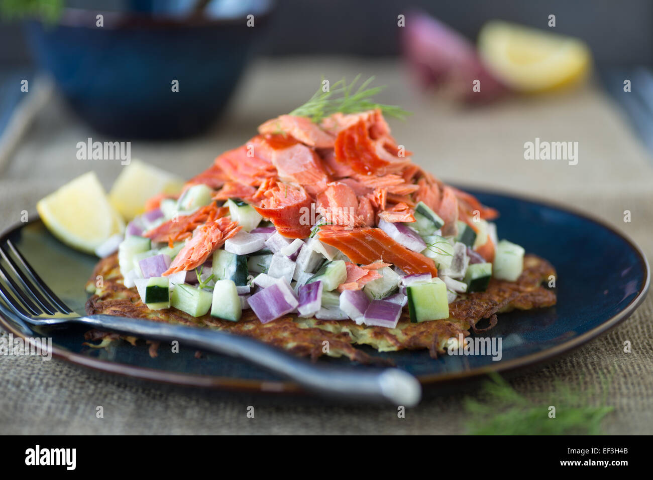 Leckere süße Kartoffel Rösti mit Gurkensalat und geräuchertem Lachs Stockfoto