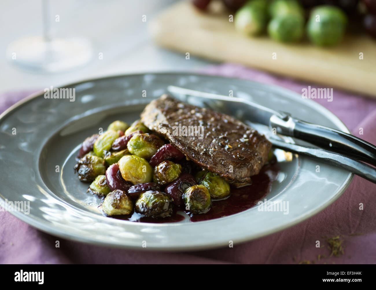 Flanken-Steak mit Gebratener Rosenkohl, Trauben und Rotweinsauce Stockfoto