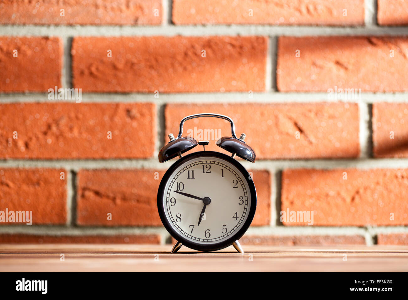 Die alte Uhr vor einer Mauer Stockfoto