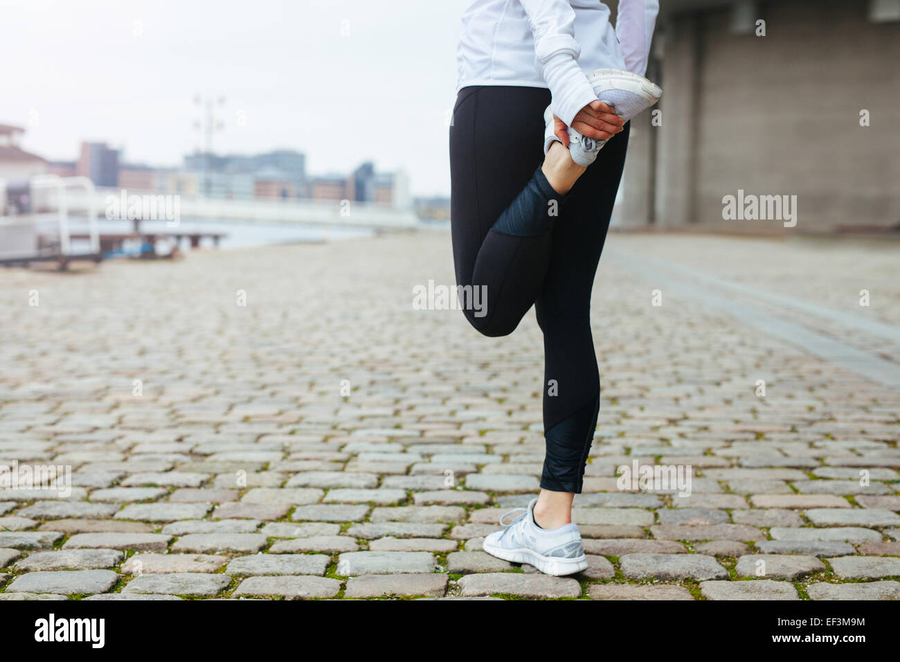 Niedrige Schnittansicht Fit jungen Frau streckt ihr Bein vor einem Lauf in Straßen der Stadt. Vorbereitung für das Training ausführen. Stockfoto