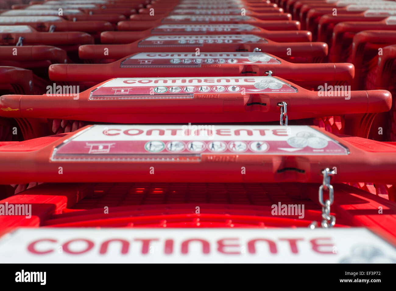 roten Continente Supermarkt Trollies mit Pay Entriegelungsmechanismus zusammen gestapelt Stockfoto