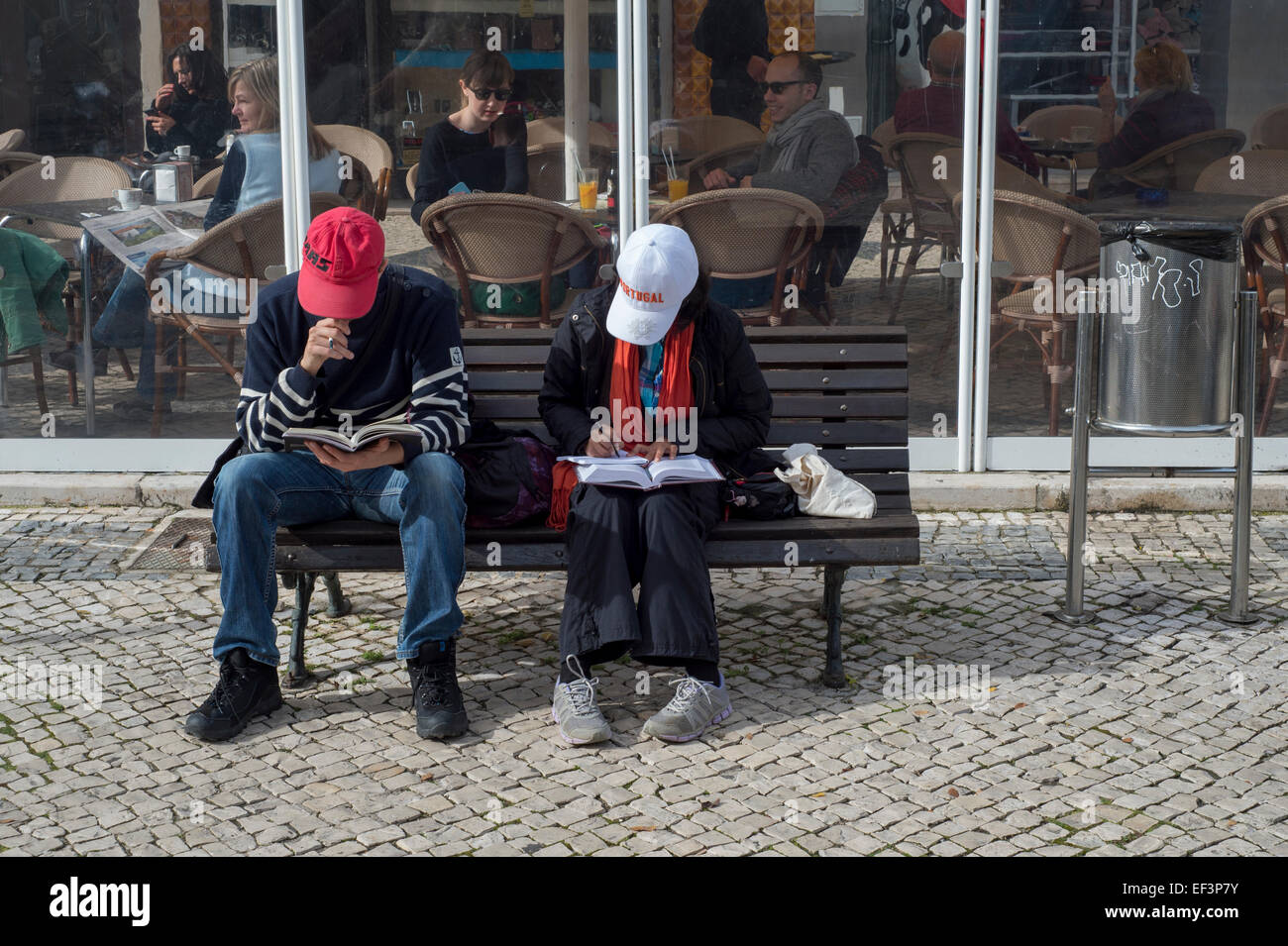 ein paar Touristen sitzen auf einer Bank schreiben, Lagos, Portugal Stockfoto