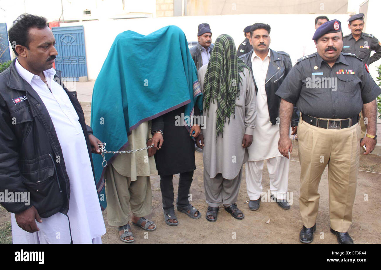 Polizei-Mitarbeiter begleiten inhaftierte Straftäter während Junaid Ahmed Sheikh, SSP Bezirk Korangi Media briefing in SSP Korangi Büro in Karachi auf Montag, 26. Januar 2015. Stockfoto