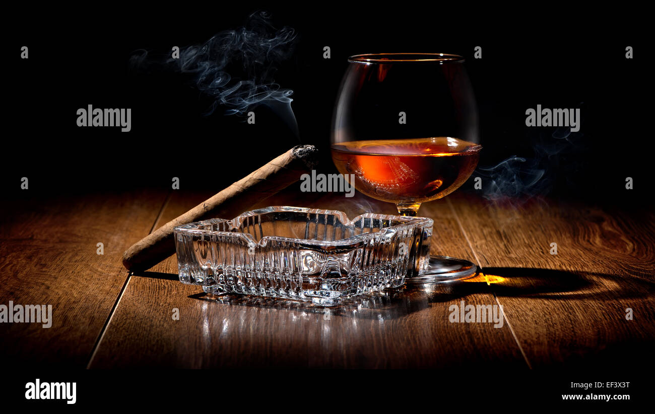 Zigarren Aschenbecher und Cognac auf einem Holztisch Stockfoto