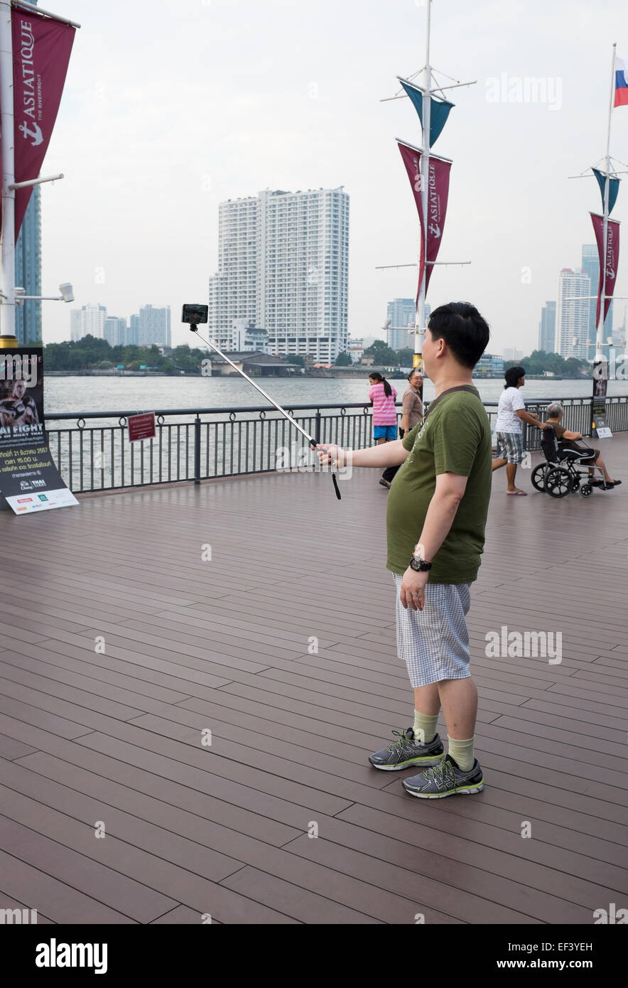 Posiert mit Handy-Kamera auf einem Selfie Stick am Asiatique Riverfront in Bangkok Stockfoto