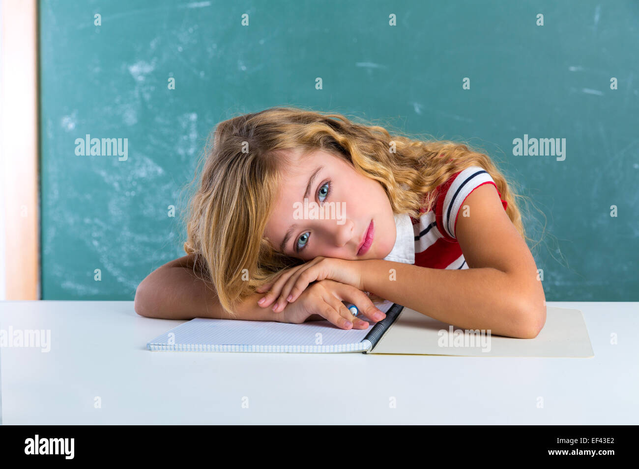 Langweilige traurigen Ausdruck Schüler Schülerin auf Klassenzimmer Schreibtisch bei der Schulbehörde grüne Kreide Stockfoto