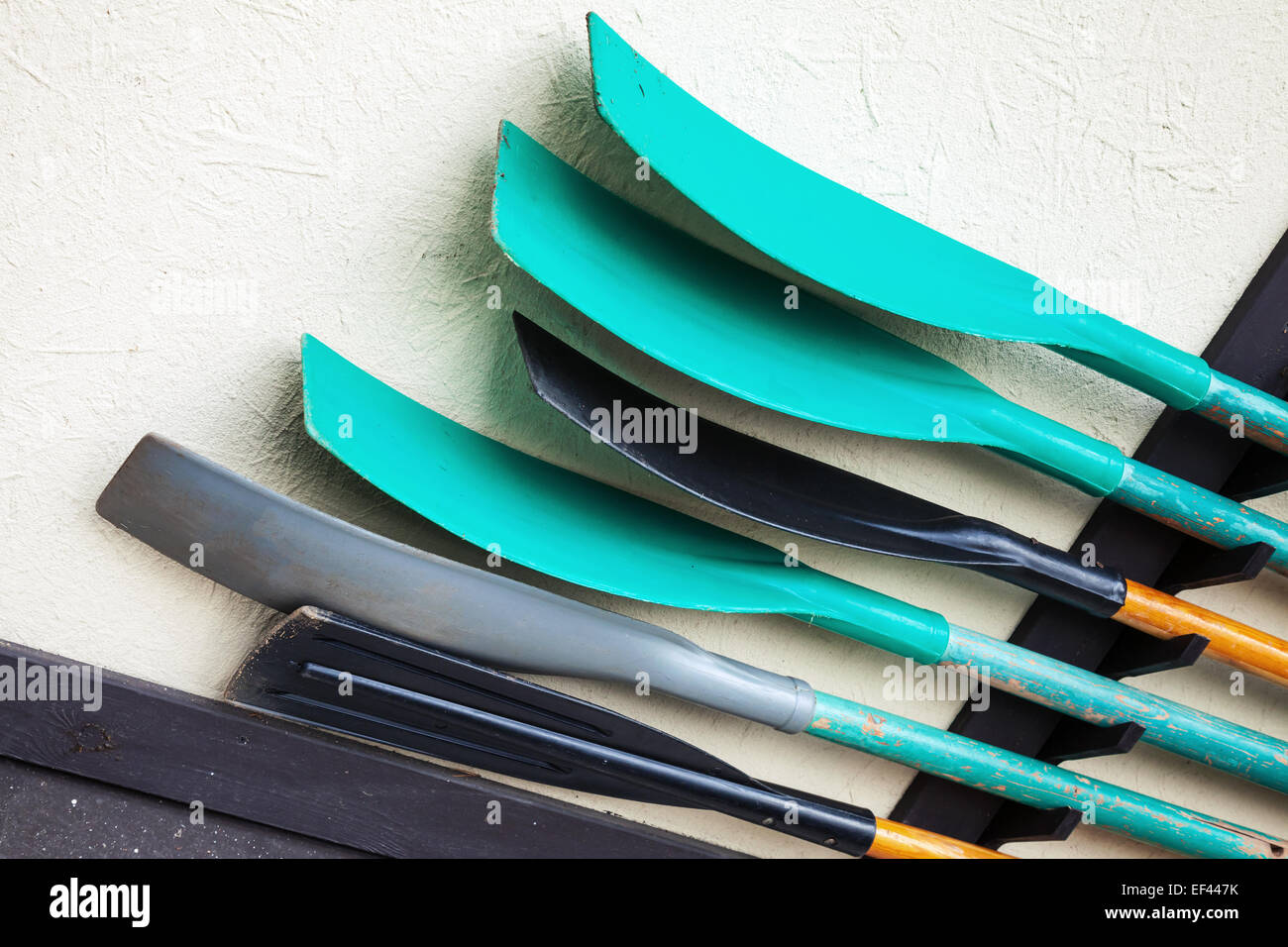 Gruppe von grünen und schwarzen Paddel auf graue ländlichen Wand montiert Stockfoto