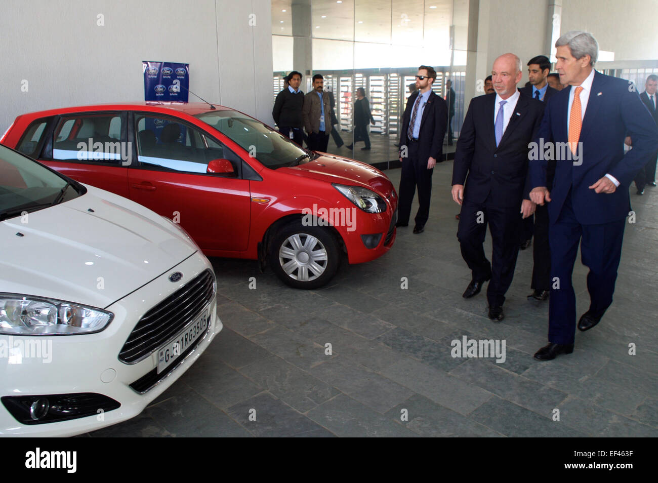 Nigel Harris, der Präsident von Ford Indien, zeigt neue Pkw-Modelle, US-Außenminister John Kerry, wie er ein neues Ford Motor Co. Werk in Sanand, Indien, in der Stadt für die Vibrant Gujarat-Gipfel am 12. Januar 2015 eröffnen Touren. Stockfoto