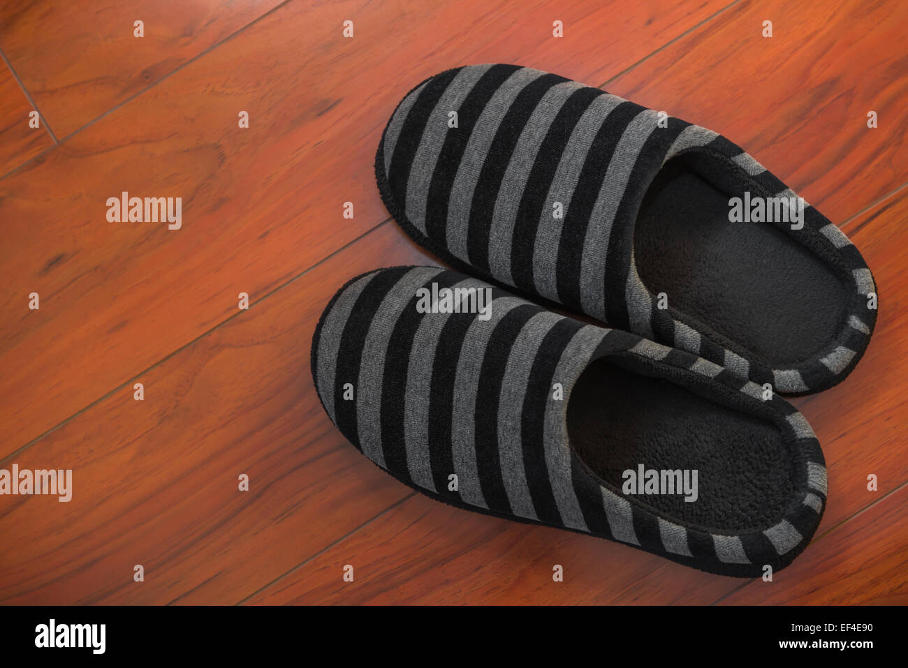 Paar schwarze Schuhe für Mann auf Holzboden im Schlafzimmer Stockfoto