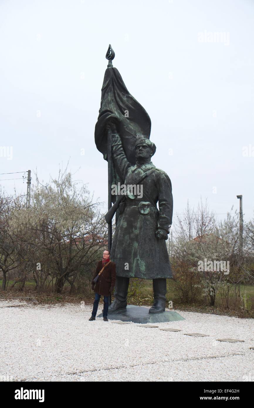 Mann stehend neben riesigen Skulptur des Flag-tragenden Soldaten Stockfoto