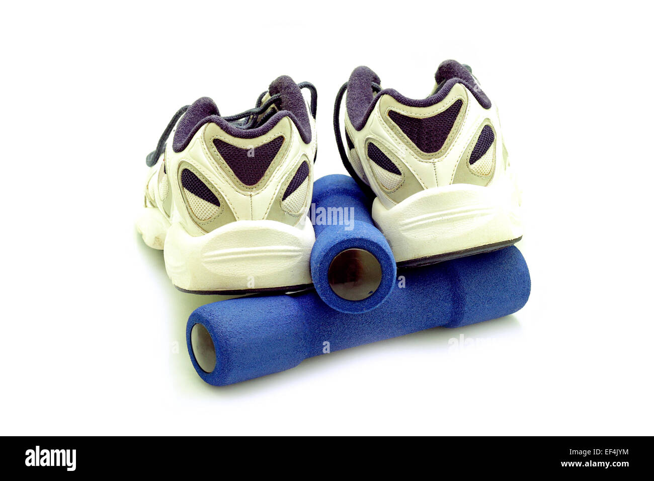 Sportschuhe und Hanteln auf weißem Hintergrund Stockfoto