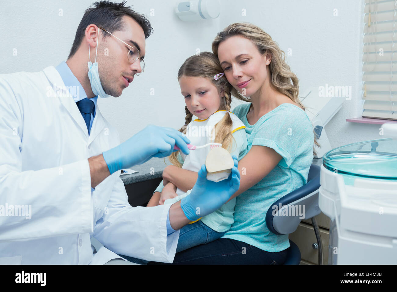 Zahnarzt mit Assistent Mädchen beibringen, wie man Zähne putzen Stockfoto