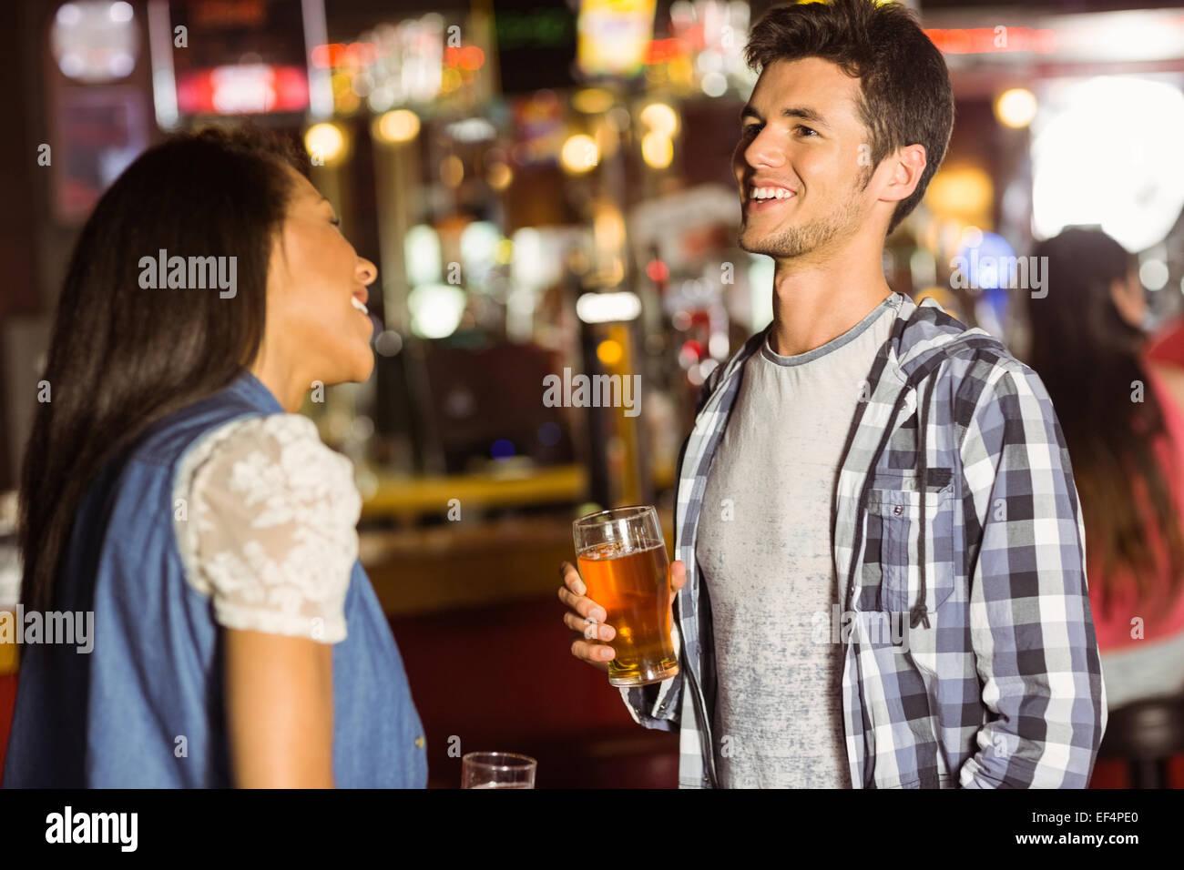 Lächelnd Freunden sprechen und trinken Bier und Mixgetränk Stockfoto