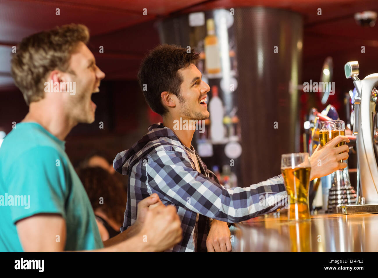 Glückliche Freunde sitzen und trinken Bier Stockfoto