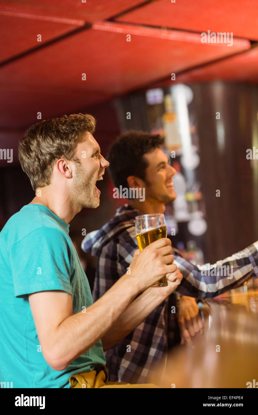 Glückliche Freunde sitzen und trinken Bier Stockfoto