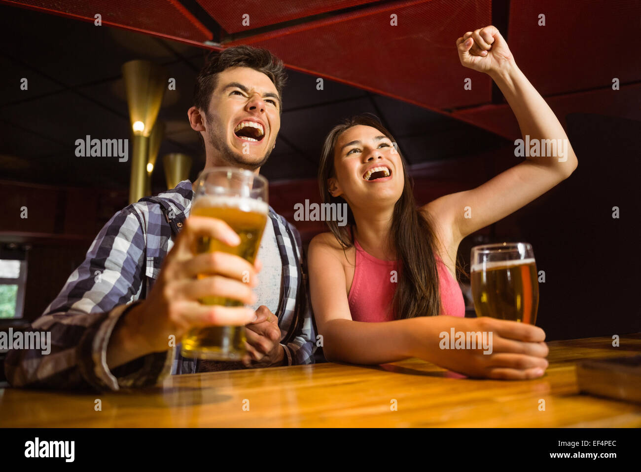 Glückliche Freunde Bier trinken und zusammen jubeln Stockfoto