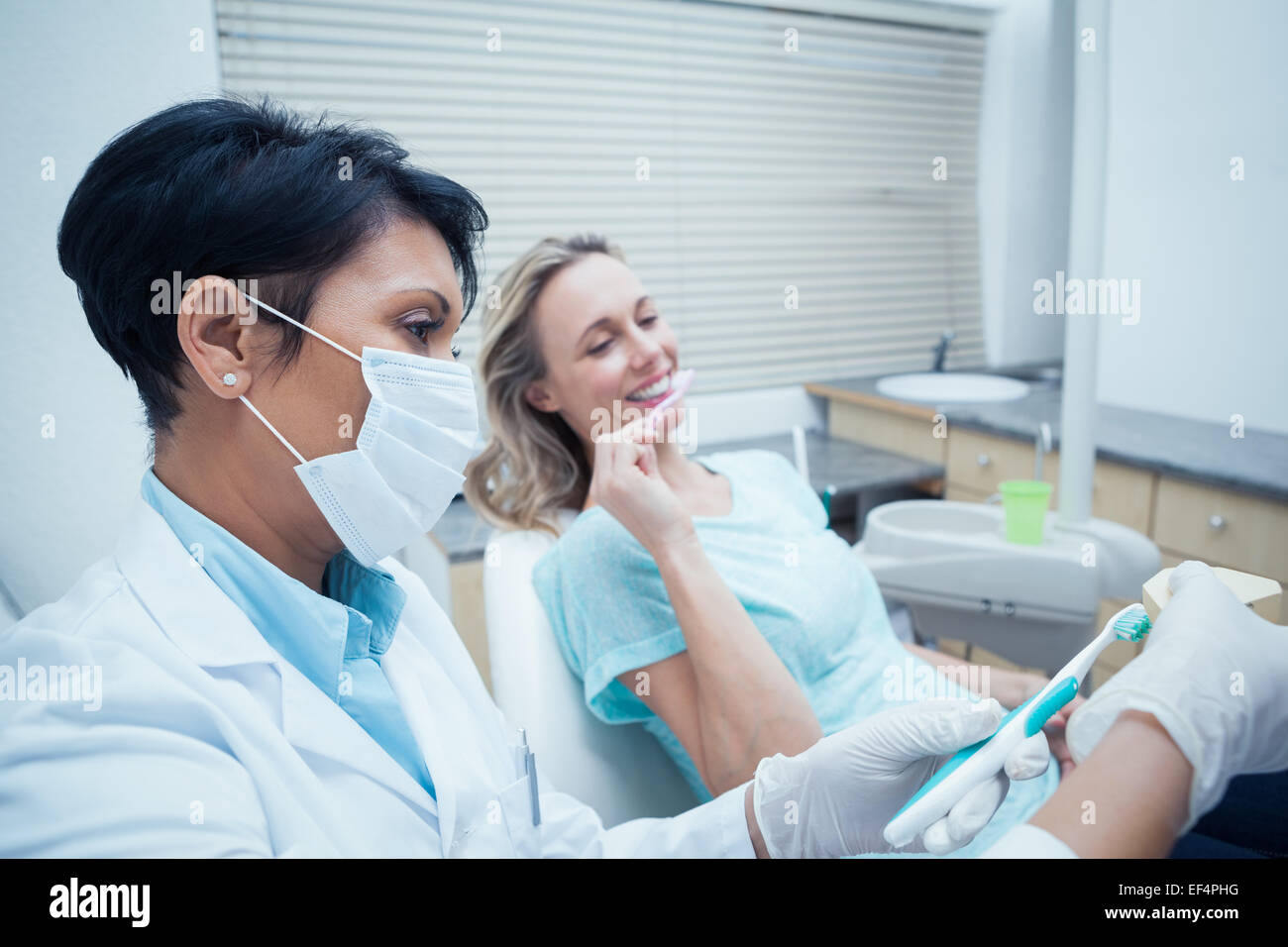 Frau zeigt, wie man Zähne putzen Zahnarzt Stockfoto