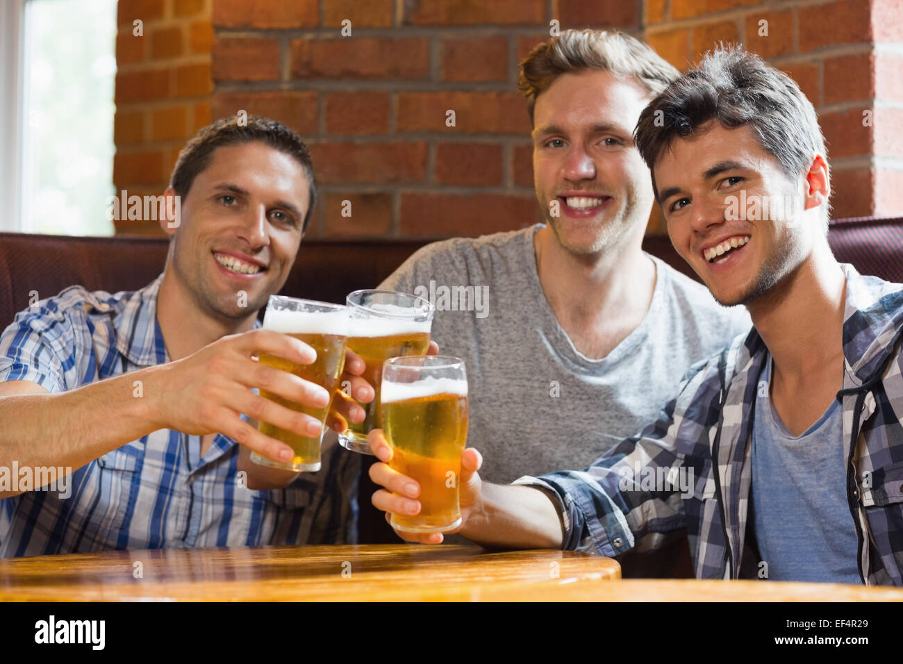 Glückliche Freunde Toasten mit Pints Bier Stockfoto