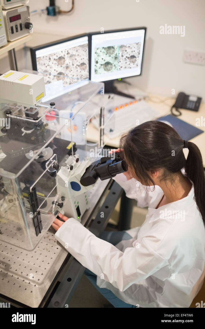 Biochemie-Student mit großes Mikroskop und computer Stockfoto