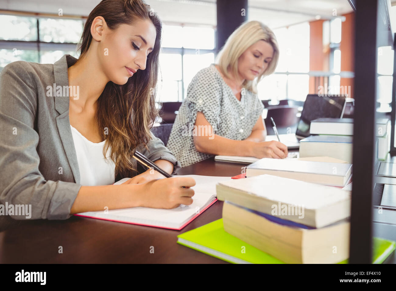 Reift Weibchen Studenten schreiben von Notizen am Schreibtisch Stockfoto