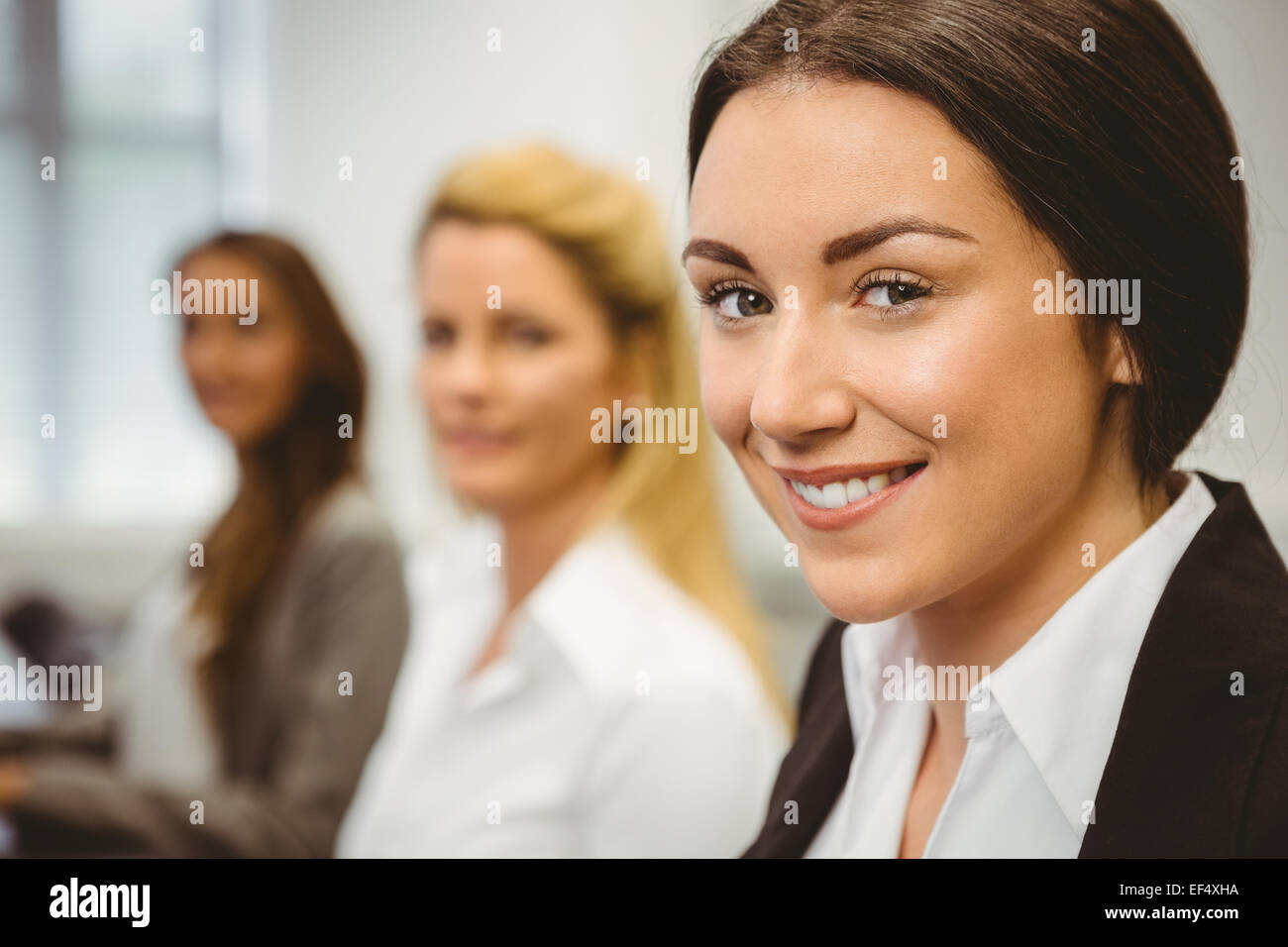 Glückliche Frauen im Computerraum lächelnd in die Kamera Stockfoto