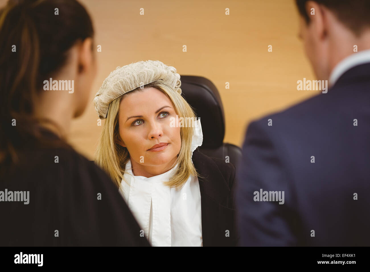Richter und Anwalt hören den Verbrecher in Handschellen Stockfoto