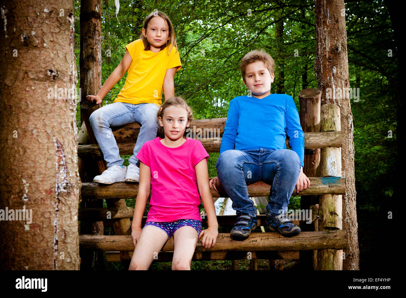 Kinder sitzen auf einem Baum-Haus, München, Bayern, Deutschland Stockfoto