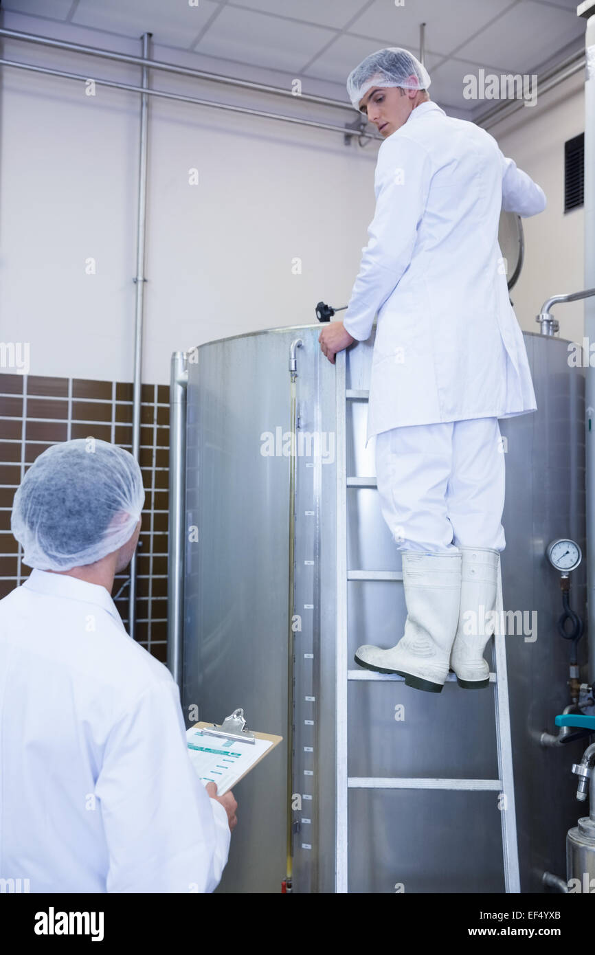 Kolleginnen und Kollegen sprechen, während im stehen auf der Leiter Stockfoto