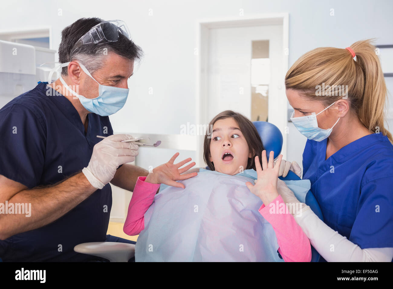 Angst, junge Patienten protestieren über Zahnarzt und seine Krankenschwester Stockfoto