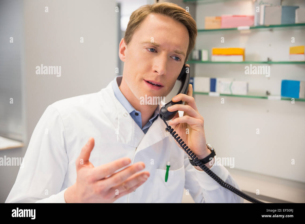 Ernsthafte Apotheker am Telefon Stockfoto