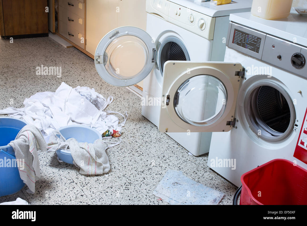 zwei große Waschmaschinen mit die schmutzige Wäsche in der Waschküche des Kindergartens Stockfoto