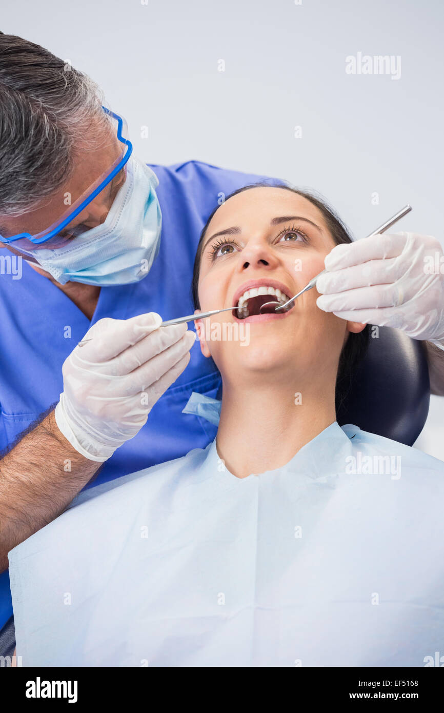 Zahnarzt, die Untersuchung eines Patienten mit Winkel Spiegel und Sichel Sonde Stockfoto