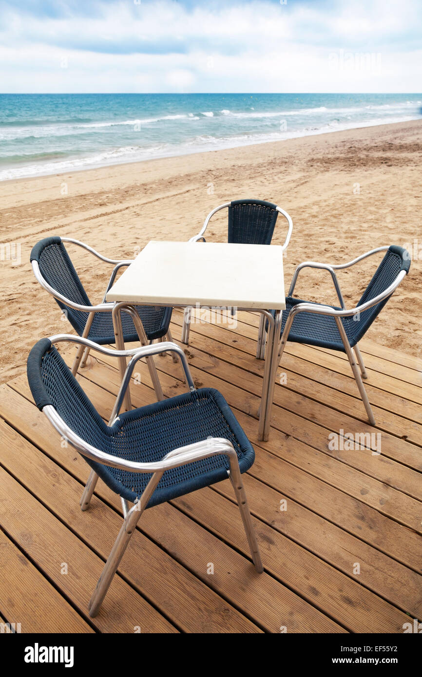 Freifläche am Meer Bar Interieur mit Holzboden und Metall Sessel am Sandstrand Stockfoto