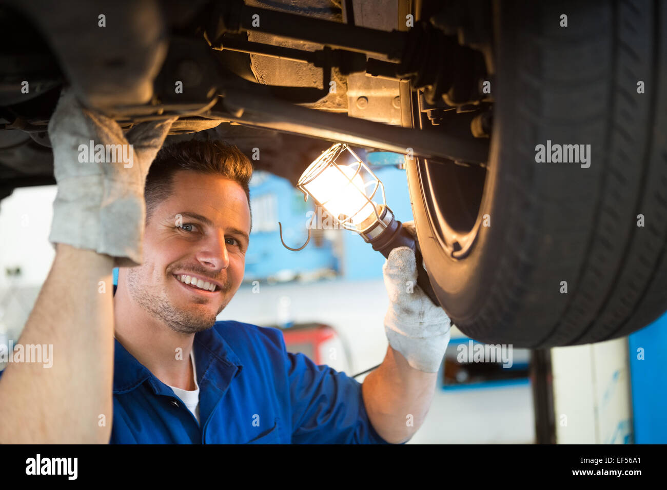 Mechaniker, die leuchtende Fackel unter Auto Stockfoto