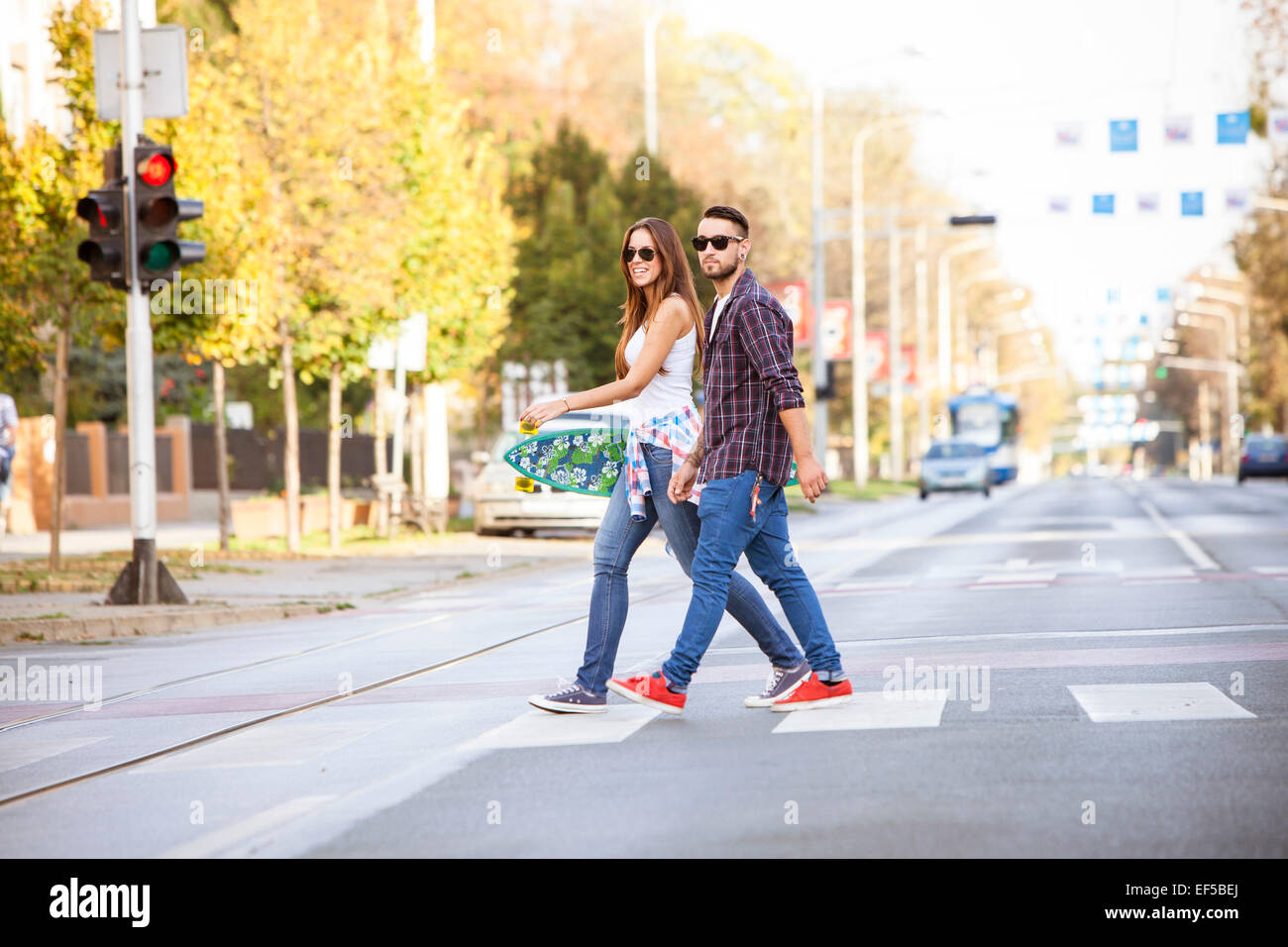 Junges Paar mit Skateboard Kreuzung Stadtstraße Stockfoto