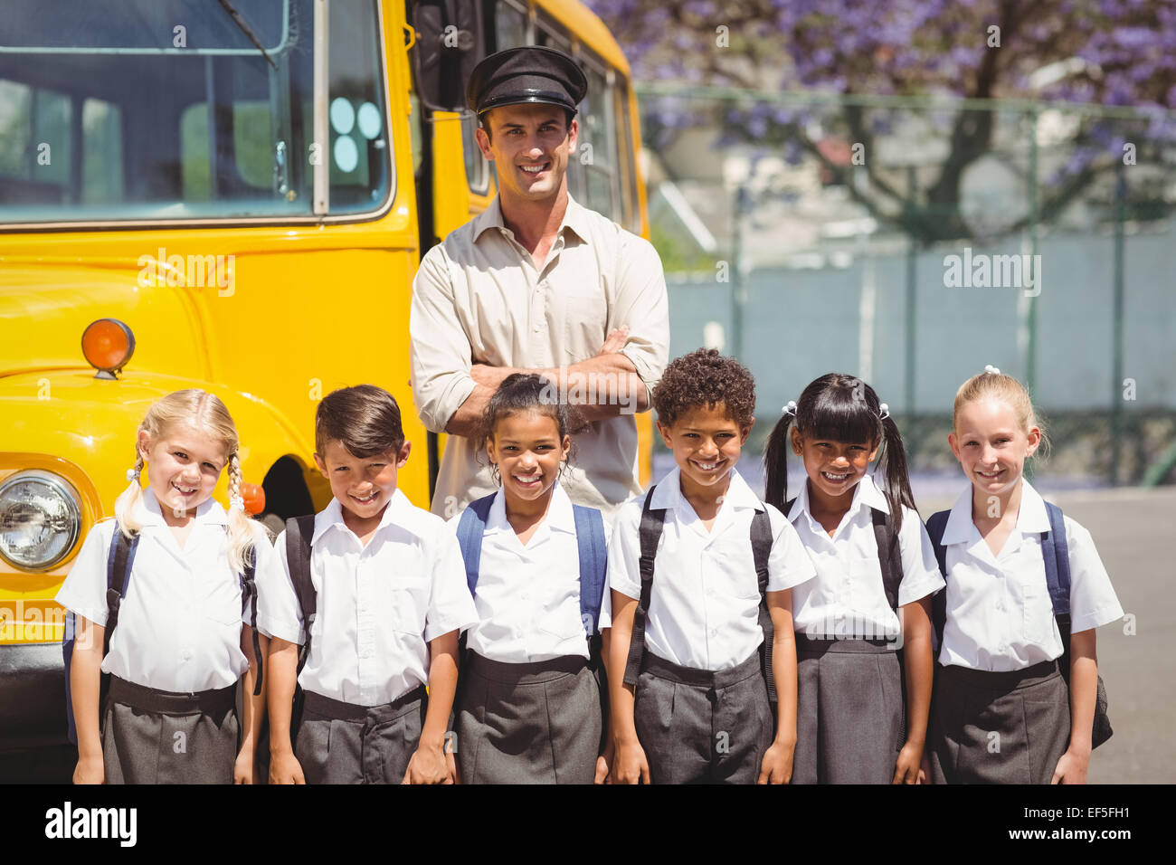 Niedlichen Schülerinnen und Schüler mit ihrer Schule Busfahrer Stockfoto