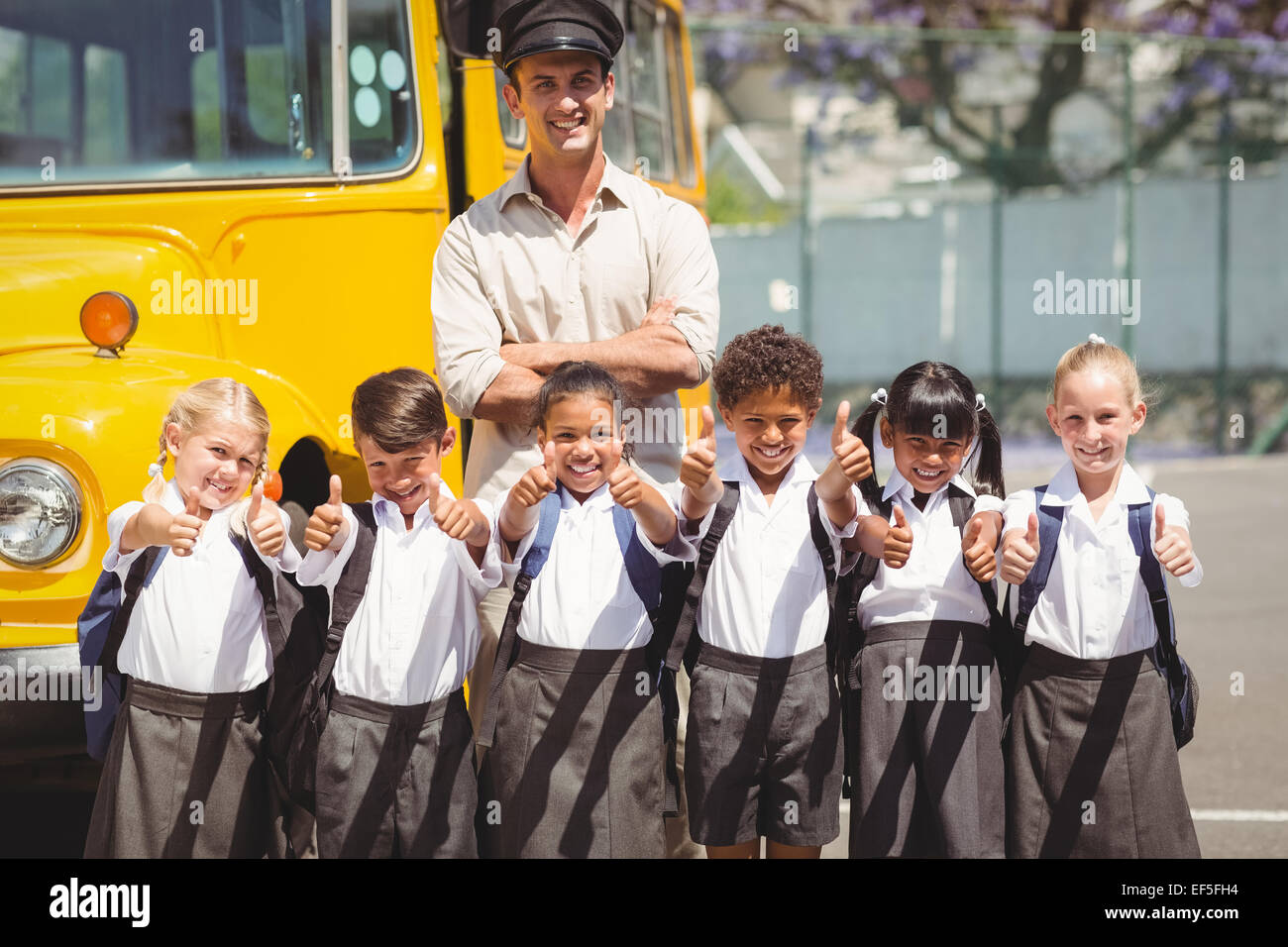 Niedlichen Schülerinnen und Schüler mit ihrer Schule Busfahrer Stockfoto