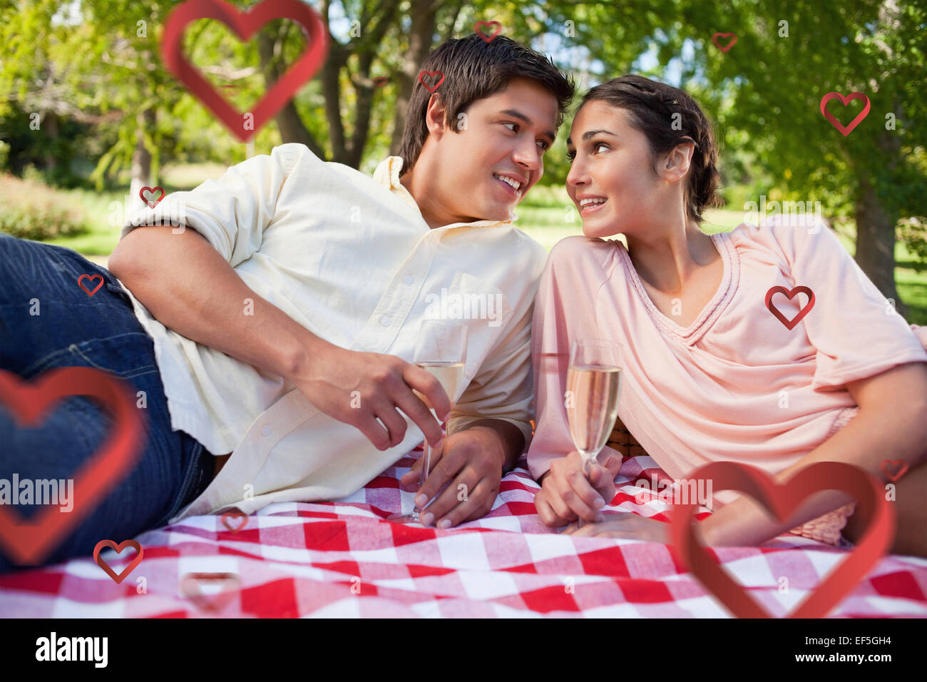 Zusammengesetztes Bild zwei Freunde sahen einander beim Picknicken Stockfoto