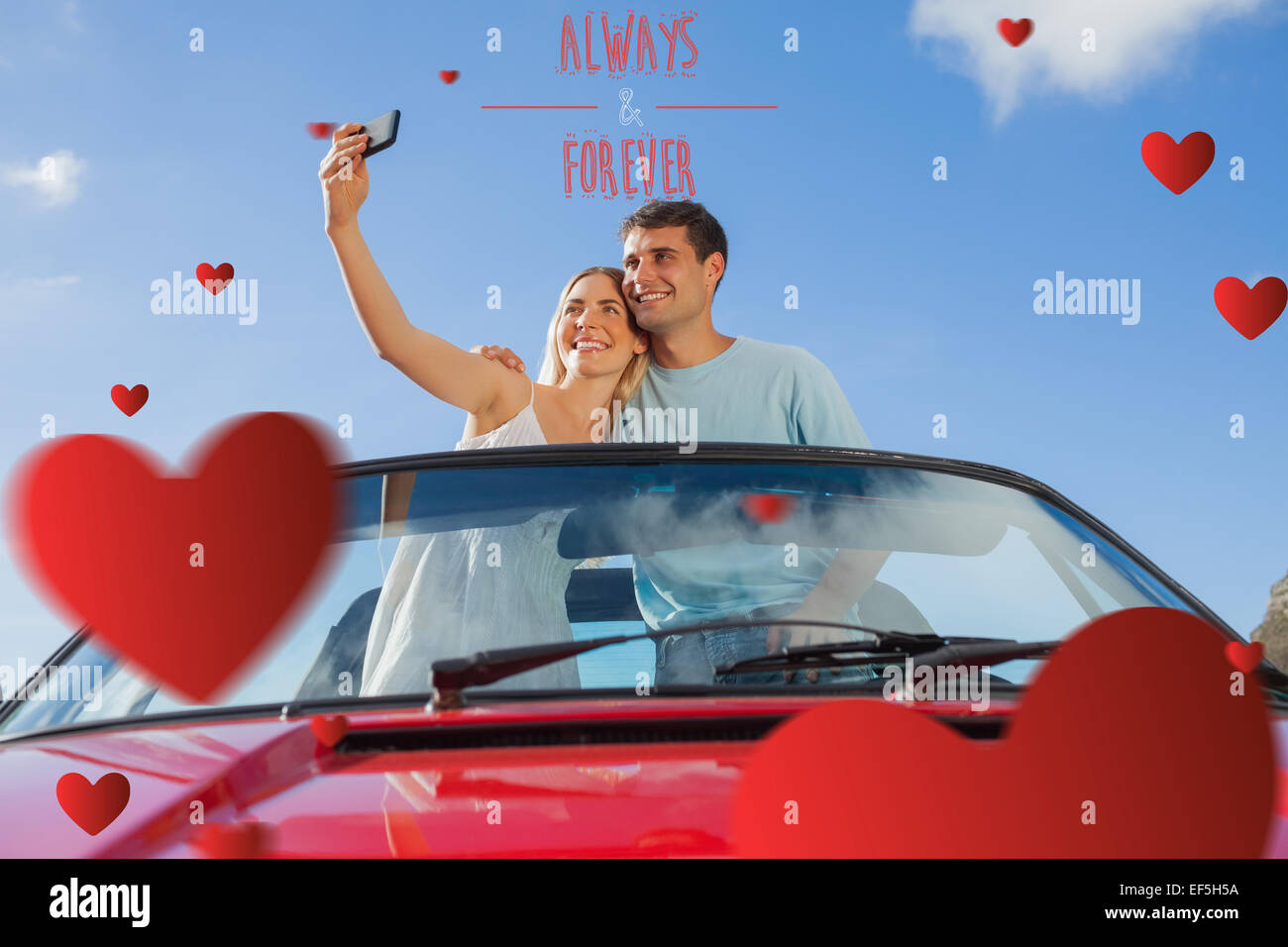 Zusammengesetztes Bild fröhlich paar stehend im roten Cabriolet unter Bild Stockfoto