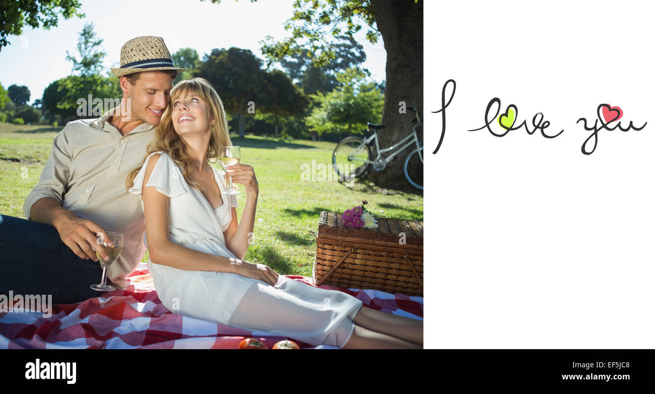 Zusammengesetztes Bild des süße paar trinken Weißwein auf ein Picknick Lächeln einander an Stockfoto