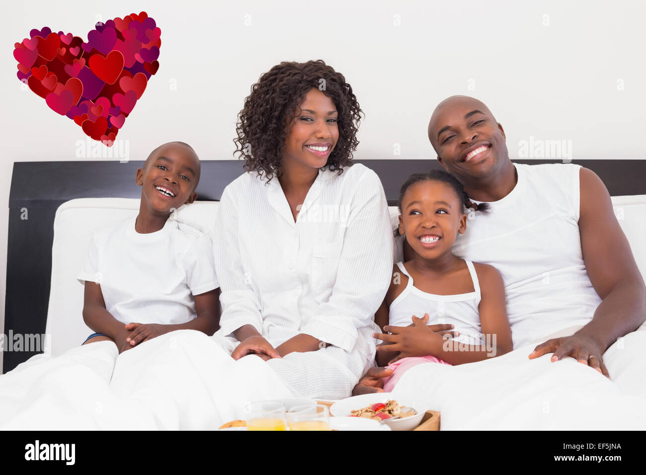 Zusammengesetztes Bild der glücklichen Familie mit Frühstück im Bett Stockfoto