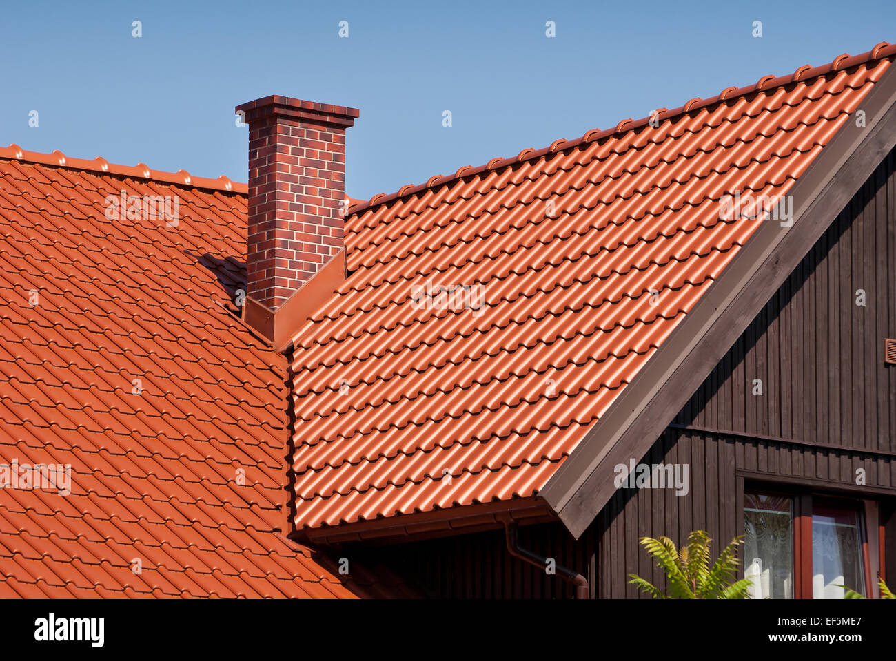 Überlappende roten Fliesen Reihen Laken Dach und Schornstein Stockfoto