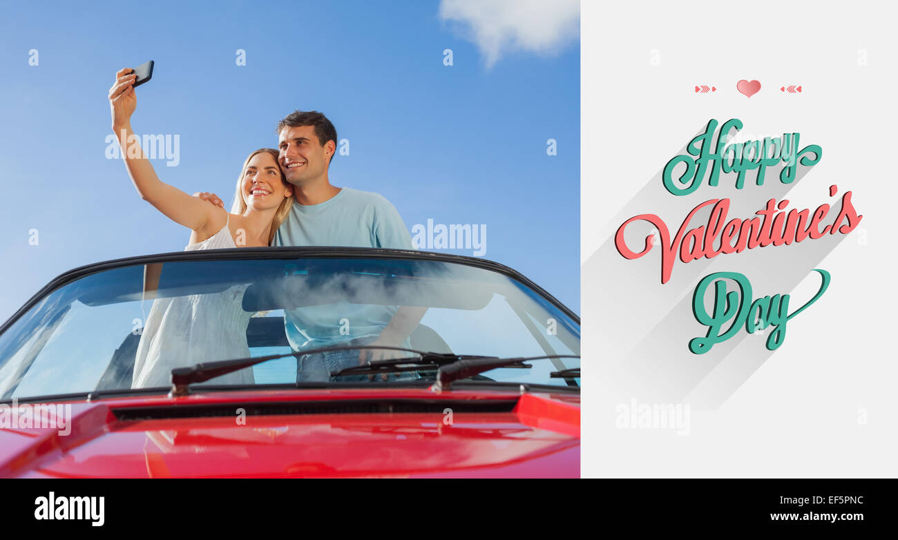 Zusammengesetztes Bild fröhlich paar stehend im roten Cabriolet unter Bild Stockfoto