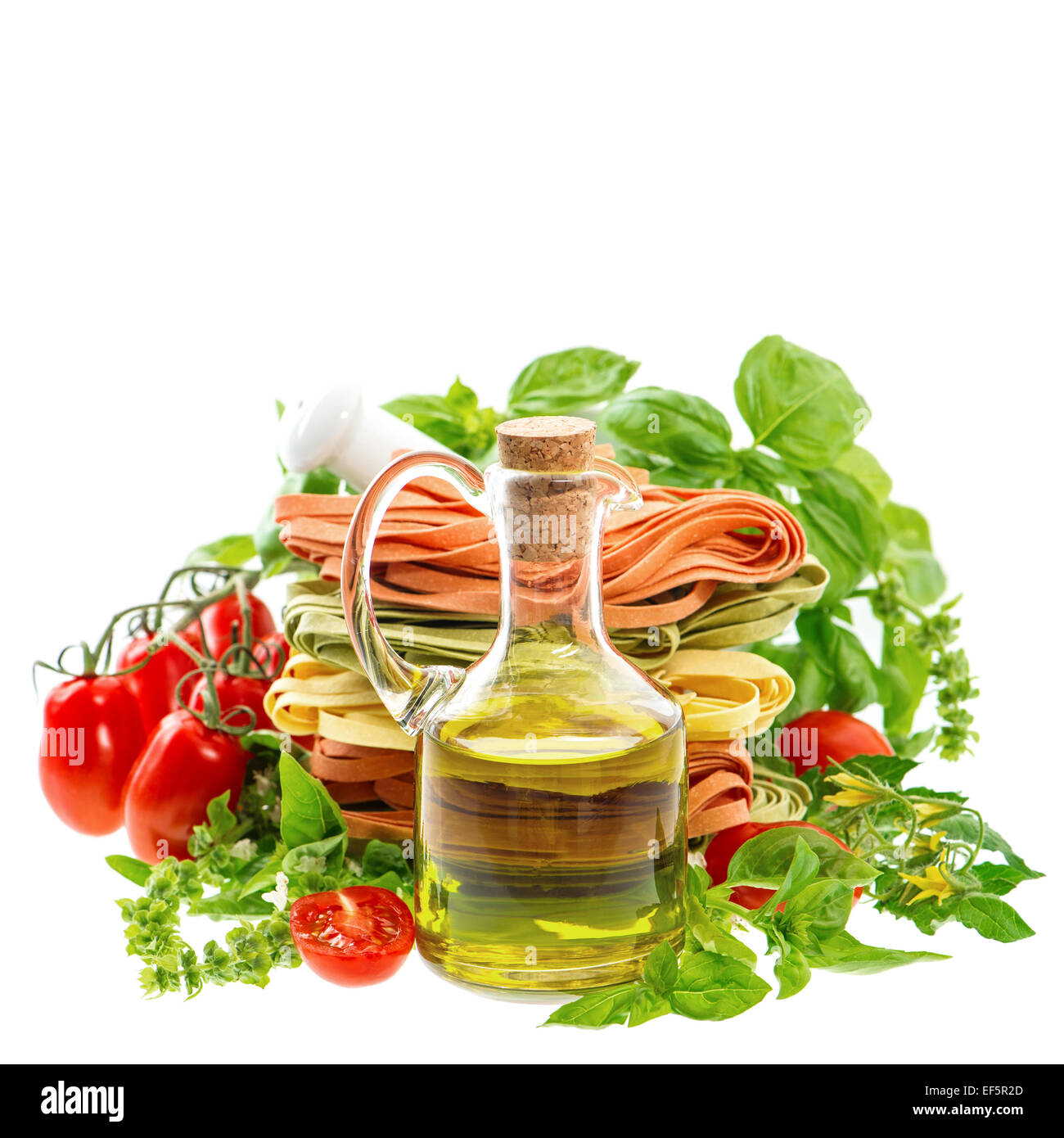 Olivenöl mit italienischer Pasta, Kräuter und Tomaten, isoliert auf weiss. Essen-Hintergrund Stockfoto