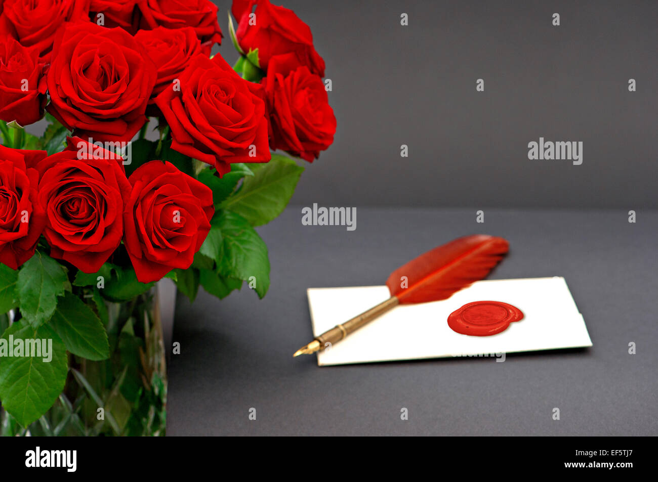 rote Rosen und Liebesbrief auf schwarzem Hintergrund. festliche Blumenarrangement. Einladung oder Grüße Karte-Konzept Stockfoto