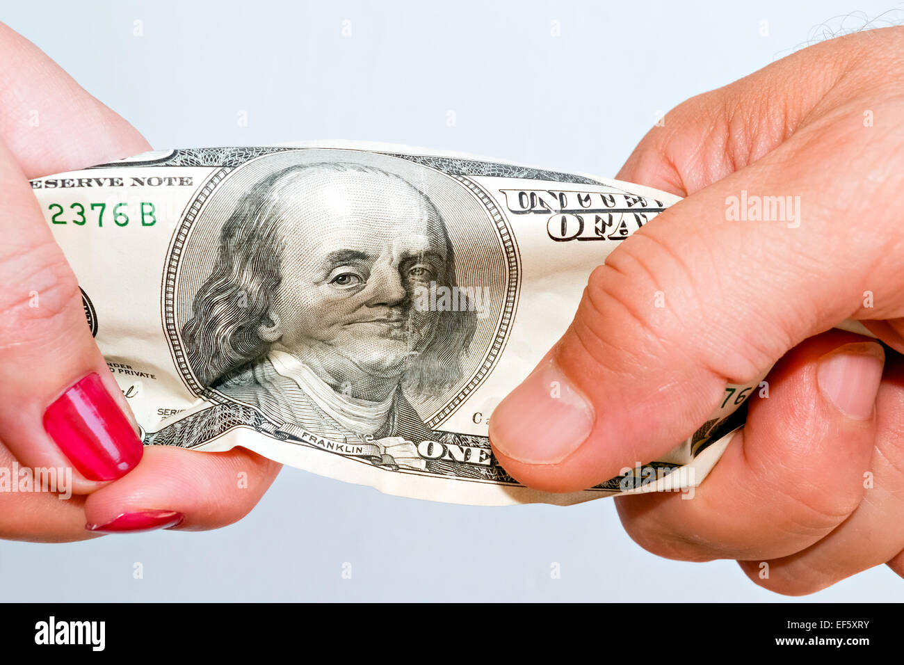 Zwei Hände dehnen Banknote symbolisiert die harten ökonomischen Realität Stockfoto