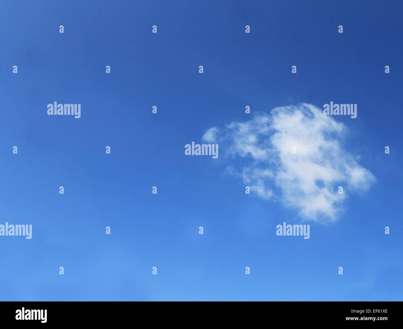 Eine kleine weiße Wolke auf einem klaren blauen Himmel Stockfoto