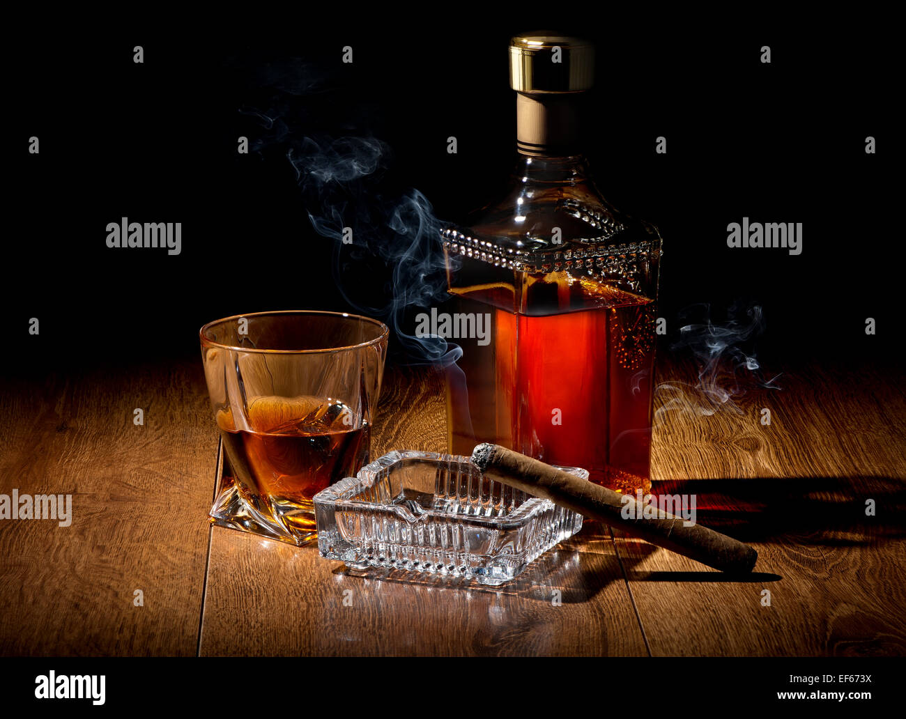 Schnaps und Zigarren auf Aschenbecher auf einem Holztisch Stockfoto