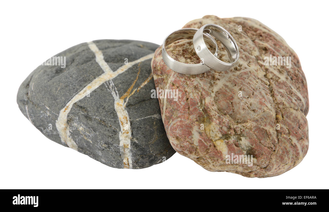 Zwei Trauringe auf Stein isoliert auf weiss. Stockfoto