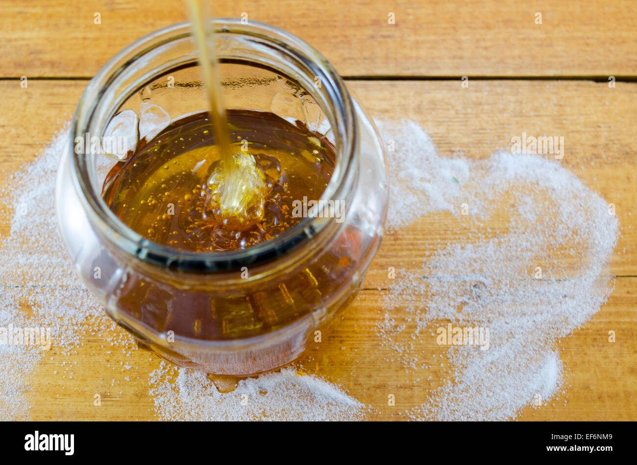 Dunkler Honig in einem Glas Tropfen Stockfoto